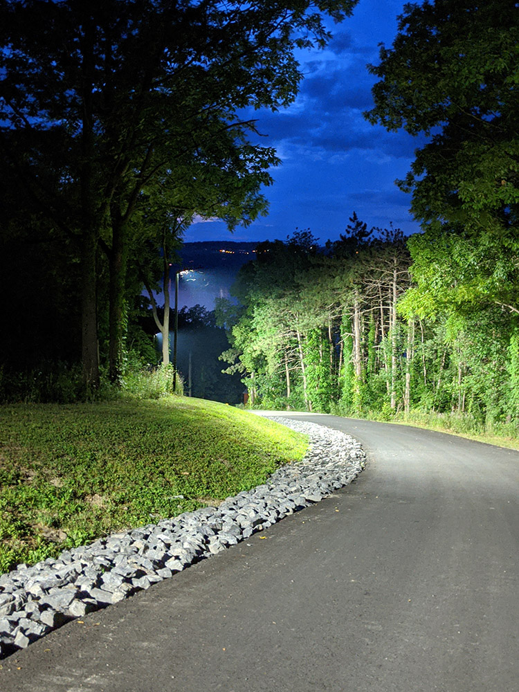 lit paved driveway at night
